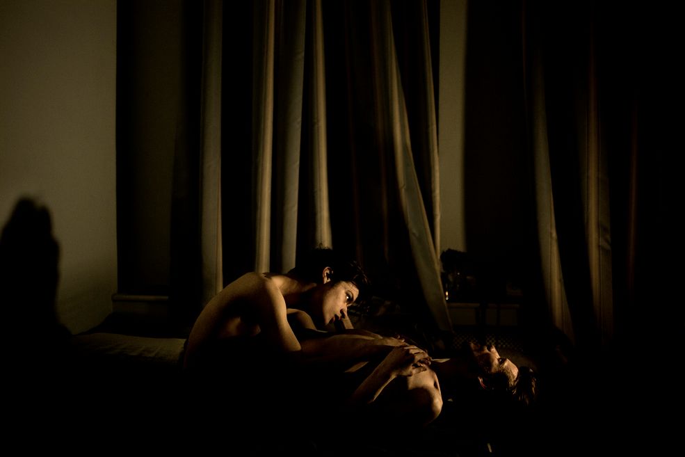 Zdjęcie przedstawia parę rosyjskich gejów, sfotografowanych w zaciemnionym pokoju. Jeden z nich leży na plecach, drugi siedząc – pochyla się nad nim. Obydwoje są nadzy. Ich twarze są oświetlone, prawdopodobnie światłem świec. Tłem fotografii są długie zasłony okienne.