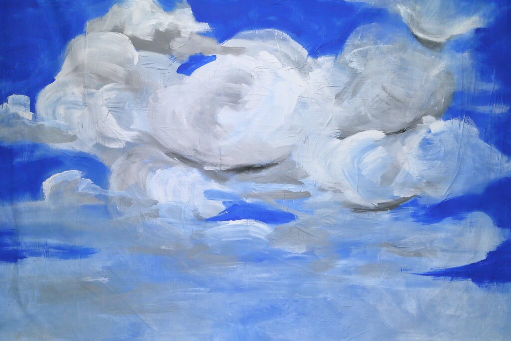 Obraz przedstawia biało-szare chmury na niebieskim tle. W górnej części obrazu chmury są gęste i duże, skumulowane w białe koła i spirale. Dół obrazu przedstawia chmury rozrzedzone w jednolity pasek szarej mgły.