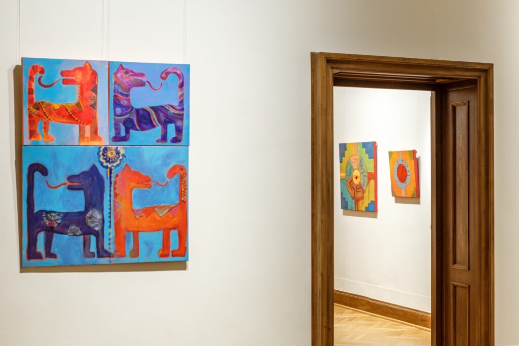 Po lewej stronie obraz z motywem czterech odwróconych smoków, niebieskich i pomarańczowych. W głębi w otwartych drzwiach dwa obrazy